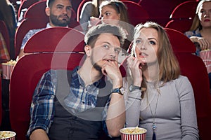 Cheerful couple having date in cinema.