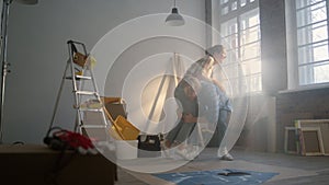 Cheerful couple having fun indoors. Joyful family dancing in new apartment..