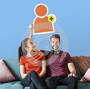 Cheerful couple holding a friend request icon