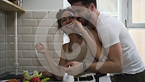 Cheerful couple hugging flirting in kitchen having romantic relationship Sbbd. wife and husband