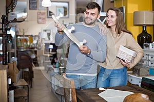 Cheerful couple looking for wall hanger