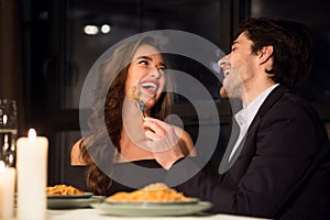 Cheerful couple in love enjoying romantic dinner in restaurant