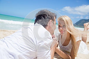 Cheerful couple lying on the beach on a sunny day