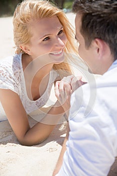 Cheerful couple lying on the beach on a sunny day