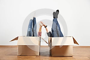 Cheerful couple lying in boxes