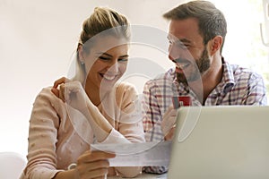 Cheerful couple paying bills.