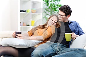 Cheerful couple relaxing together on sofa in living room