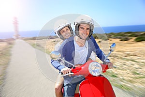 Cheerful couple riding moto on island