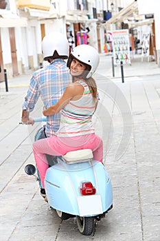 Cheerful couple riding moto in the streets