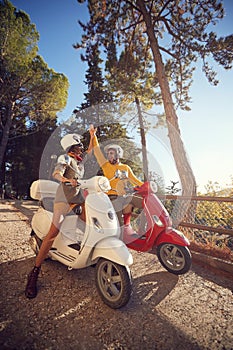 Cheerful couple riding a scooter and having fun on journey