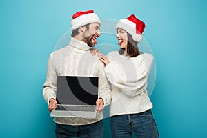 cheerful couple in santa hats sticking