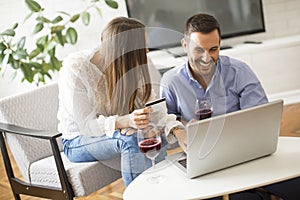 Cheerful couple searching internet and shopping online