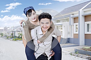 Cheerful couple showing keys of new house