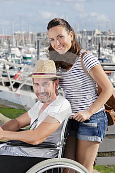 cheerful couple sititng in wheelchairs outdoors