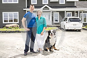 A Cheerful couple standing in front of new house