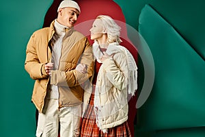 cheerful couple in stylish winter jackets