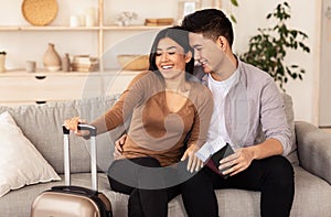 Cheerful Couple With Suitcase And Tickets Waiting For Vacation Indoor