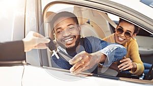 Cheerful Couple Taking Key From Dealer Sitting In Auto, Panorama