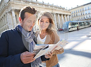 Cheerful couple in town looking at the map