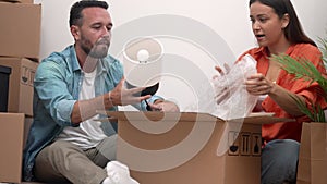 Cheerful couple unpacks moving boxes, dream home. glow of new beginning, joy in the simple moments