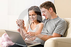 Cheerful couple using laptop together