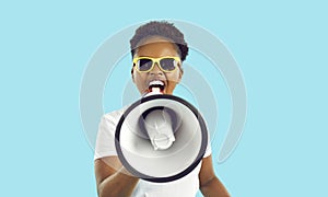 Cheerful crazy african american woman with loudspeaker in hand making loud advertisement.