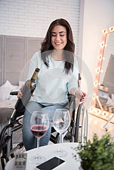 Cheerful crippled woman serving wine