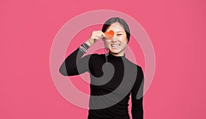 Cheerful cute asian toung woman standing over pink background an