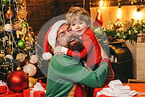 Cheerful cute child opening a Christmas present. Gift emotions. Happy son and father with Christmas gift box. New year