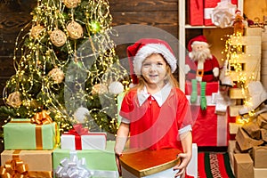 Cheerful cute child opening a Christmas present. Happy child decorating Christmas tree. Cute little child near Christmas