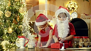 Cheerful cute children opening a Christmas present. Two Happy children daughter and son or sister and brother with