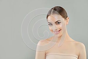 Cheerful cute young woman with clear chiny skin smiling. Facial treatment, skincare and spa concept