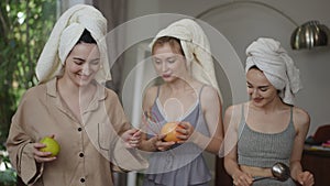 A cheerful dance of three young women with towels on their heads and kitchen utensils in their hands. Women are having