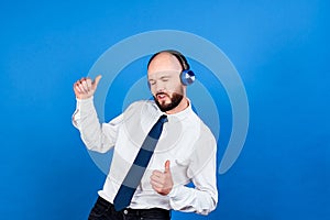 A cheerful dancing businessman in headphones on a blue background