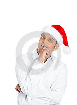 A cheerful day dreaming man in red santa claus hat
