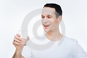 Cheerful delighted man preparing to drink water