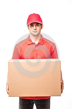 Cheerful delivery man happy young courier holding a cardboard box and smiling while standing on white background