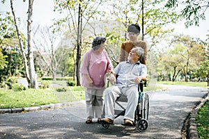 Cheerful disabled grandfather in wheelchair welcoming his happy