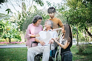 Cheerful disabled grandfather in wheelchair welcoming his happy