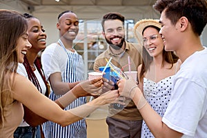 Cheerful diverse friends cheering with lemonade at barbecue dinner party