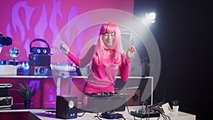 Cheerful dj performing electronic music during concert