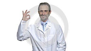 Cheerful doctor or scientist giving ok sign.