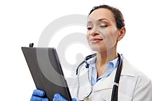 Cheerful doctor with stethoscope around her neck holding digital tablet on hands isolated on white background with copy space