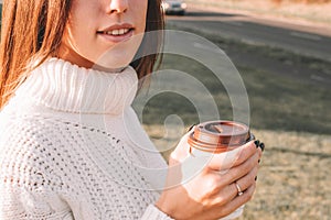 Cheerful drinking coffee. Happy young girl with cup of tea in sunshine light enjoying her morning coffee. Beautiful woman