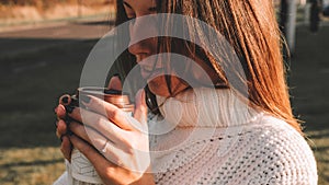 Cheerful drinking coffee. Happy young girl with cup of tea in sunshine light enjoying her morning coffee. Beautiful woman