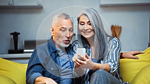 cheerful elderly interracial couple in modern