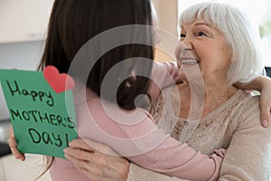 Cheerful elderly lady looking at her loving daughter