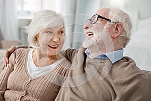 Cheerful elderly man hugging his wife