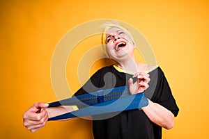 Cheerful elderly woman in a black t-shirt holds an elastic band for workouts and stretches it