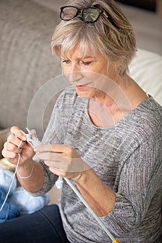 cheerful elderly woman holding knitting needles